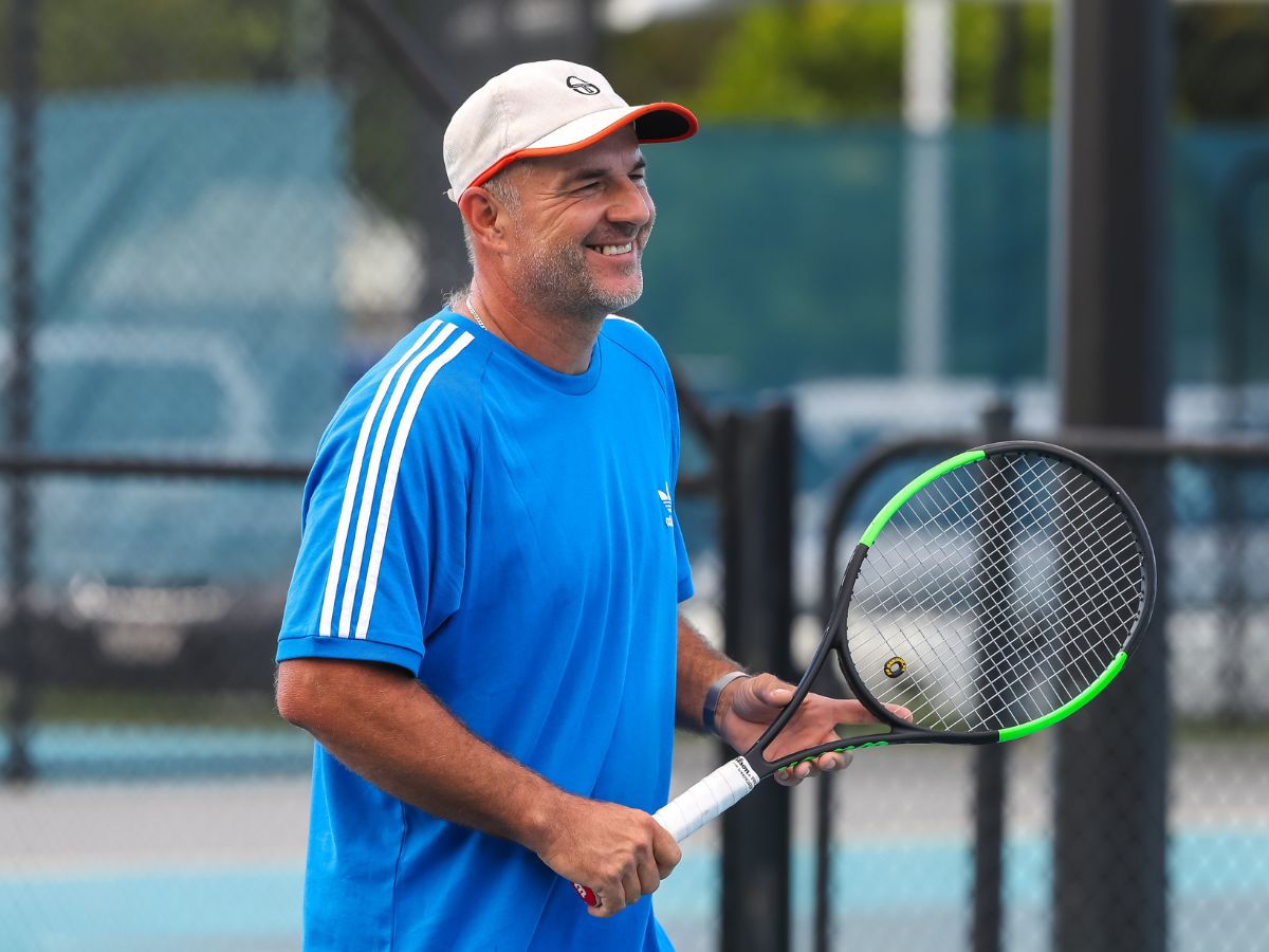 Male masters competitor smiling with tennis racket
